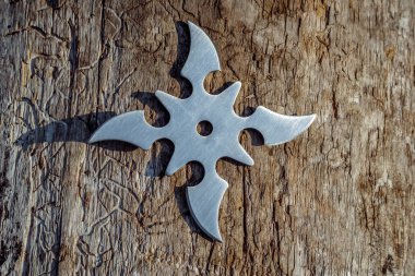 Shuriken (fırlatma yıldızı), geleneksel Japon Ninja soğuk silahı ahşap arka planda sıkışmış