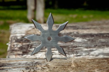 Shuriken (fırlatma yıldızı), geleneksel Japon Ninja soğuk silahı ahşap arka planda sıkışmış