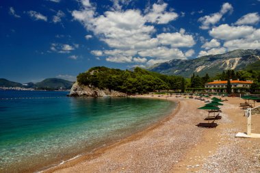 Şemsiye ve Adriyatik Denizi üzerinde güzel bir kumsal. Karadağ