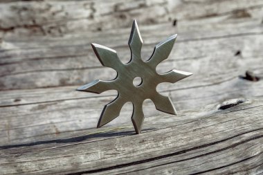 Shuriken (fırlatma yıldızı), geleneksel Japon Ninja soğuk silahı ahşap arka planda sıkışmış
