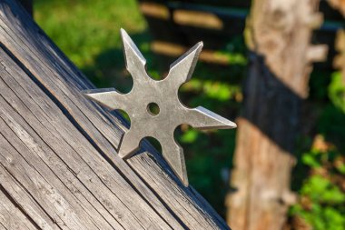 Shuriken (fırlatma yıldızı), geleneksel Japon Ninja soğuk silahı ahşap arka planda sıkışmış