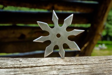 Shuriken (fırlatma yıldızı), geleneksel Japon Ninja soğuk silahı ahşap arka planda sıkışmış