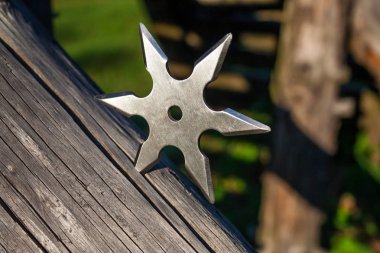 Shuriken (fırlatma yıldızı), geleneksel Japon Ninja soğuk silahı ahşap arka planda sıkışmış