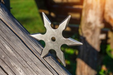 Shuriken (fırlatma yıldızı), geleneksel Japon Ninja soğuk silahı ahşap arka planda sıkışmış