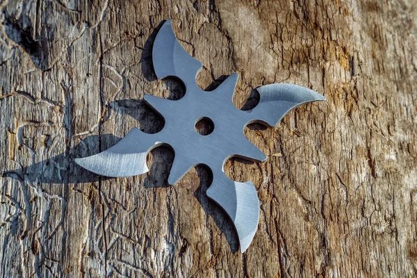 Shuriken (fırlatma yıldızı), geleneksel Japon Ninja soğuk silahı ahşap arka planda sıkışmış