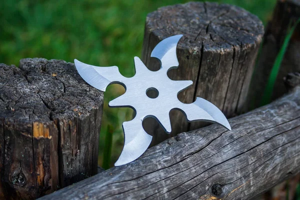 Shuriken (fırlatma yıldızı), geleneksel Japon Ninja soğuk silahı ahşap arka planda sıkışmış