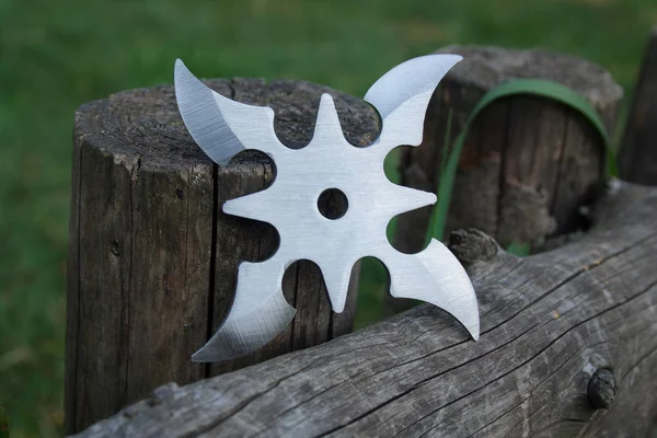 Shuriken (fırlatma yıldızı), geleneksel Japon Ninja soğuk silahı ahşap arka planda sıkışmış