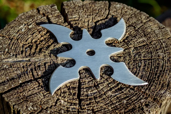 Shuriken (fırlatma yıldızı), geleneksel Japon Ninja soğuk silahı ahşap arka planda sıkışmış