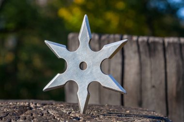 Shuriken (fırlatma yıldızı), geleneksel Japon Ninja soğuk silahı ahşap arka planda sıkışmış