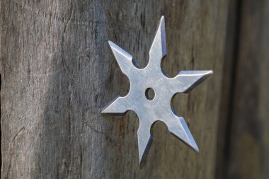 Shuriken (fırlatma yıldızı), geleneksel Japon Ninja soğuk silahı ahşap arka planda sıkışmış