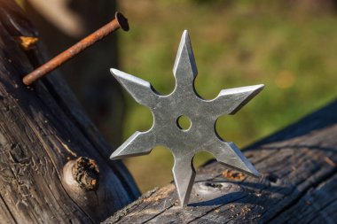 Shuriken (fırlatma yıldızı), geleneksel Japon Ninja soğuk silahı ahşap arka planda sıkışmış
