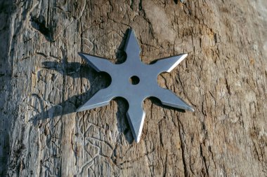 Shuriken (fırlatma yıldızı), geleneksel Japon Ninja soğuk silahı ahşap arka planda sıkışmış