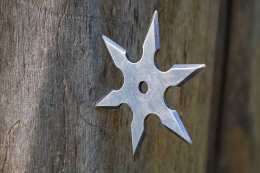 Shuriken (fırlatma yıldızı), geleneksel Japon Ninja soğuk silahı ahşap arka planda sıkışmış