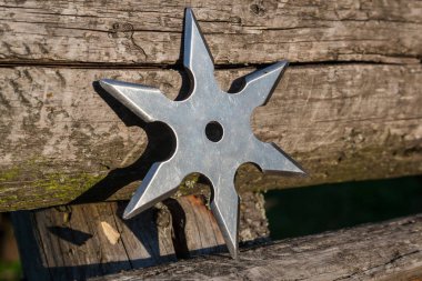 Shuriken (fırlatma yıldızı), geleneksel Japon Ninja soğuk silahı ahşap arka planda sıkışmış