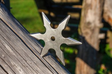 Shuriken (fırlatma yıldızı), geleneksel Japon Ninja soğuk silahı ahşap arka planda sıkışmış
