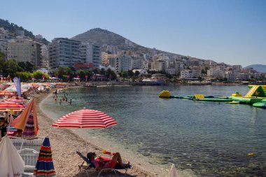 Arnavutluk. Saranda - 16 Temmuz 2018. Turistler İyon Denizi sahilinde dinleniyor.