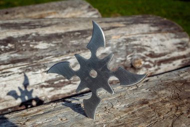 Shuriken (fırlatma yıldızı), geleneksel Japon Ninja soğuk silahı ahşap arka planda sıkışmış