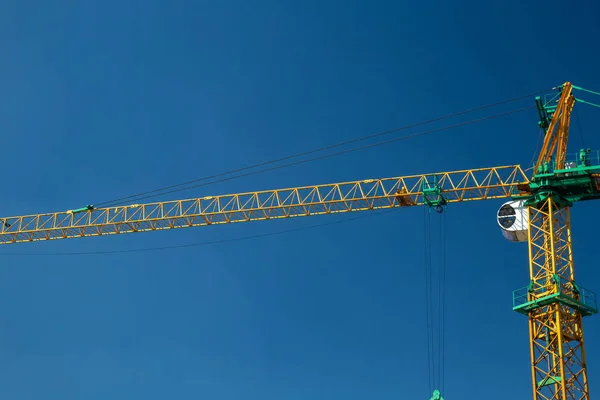 Gele bouw kraan tegen een blauwe hemel — Stockfoto