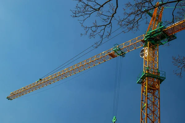 Gele bouw kraan tegen een blauwe hemel — Stockfoto