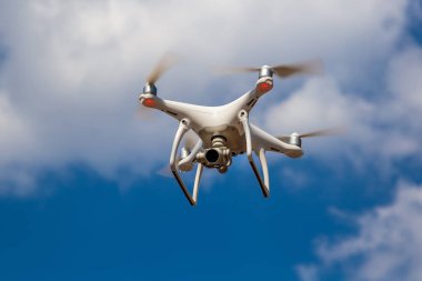 Quadcopter mavi bir gökyüzüne karşı uçuyor. Drone.