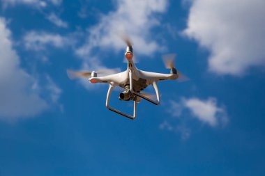 Quadcopter mavi bir gökyüzüne karşı uçuyor. Drone.