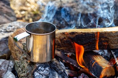 doğada açık bir ateş te çelik bardak. Ateşte yemek pişirmek. Kamp içinde
