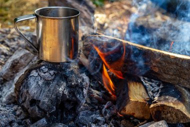 doğada açık bir ateş te çelik bardak. Ateşte yemek pişirmek. Kamp içinde