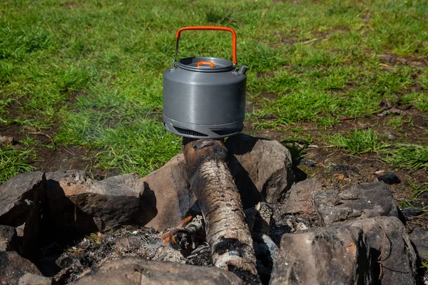 Chaleira com uma caneca em um acampamento turístico. recreação ao ar livre no C — Fotografia de Stock