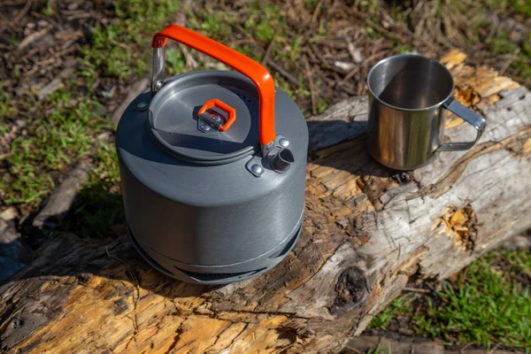 Kettle with a mug in a tourist camp. outdoor recreation in the C