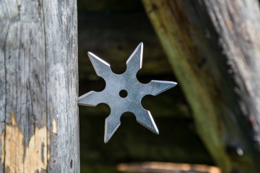 Shuriken (fırlatma yıldızı), geleneksel Japon Ninja soğuk silahı ahşap arka planda sıkışmış
