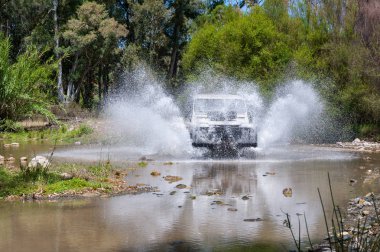 Kırsal Andalucia. İspanya. 06/10/2016. 4 x 4 arazi aracı nehir yatağı geçerken su ile hız.