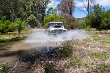 Kırsal Andalucia. İspanya. 06/10/2016. 4 x 4 arazi aracı nehir yatağı geçerken su ile hız.