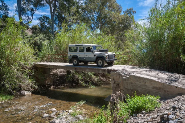 Kırsal Andalucia. İspanya. 06/10/2016. 4 x 4 nehrin karşısındaki sahipsiz güvenli olmayan beton köprü üzerinde sürüş.