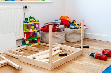 Düz paketten, çocuğun yatak odasında masası olan iki küçük sandalyeyi birleştiriyorum..