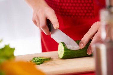 Yakın çekim. Genç kadın dilim salatalık