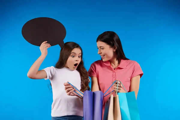 Beautiful woman and teen girl holding paper