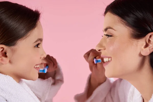 Mutter und Tochter im Kleid putzen Zähne. — Stockfoto
