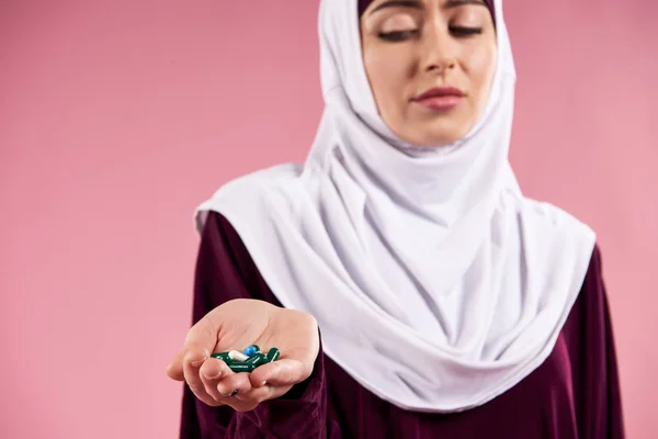 Mujer árabe en hijab sosteniendo pastillas . — Foto de Stock