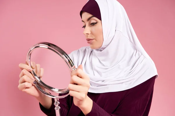 Attraente donna araba in hijab guarda allo specchio . — Foto Stock