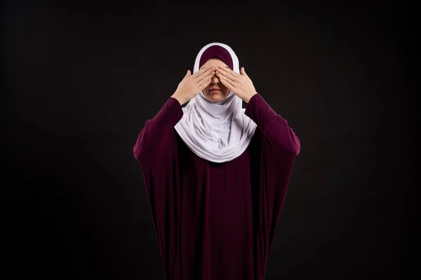 Arabische vrouw in hijab sluit ogen met palmen. — Stockfoto