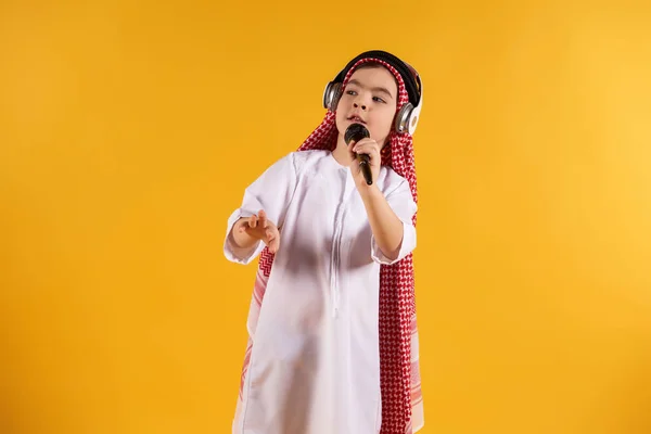 Arabische jongen in keffiyeh met microfoon zingt karaoke. — Stockfoto