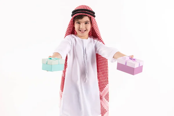 Arabian happy boy in keffiyeh presents gift boxes. — Stock Photo, Image