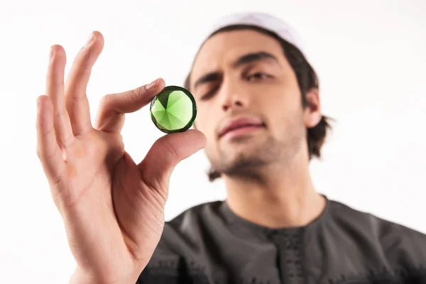 Arabische man kijkt naar kostbare groene steen. — Stockfoto