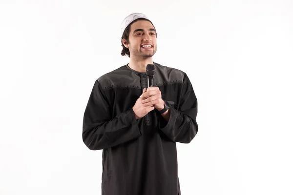 Arabisk man i etniska klädsel står med mikrofon. — Stockfoto
