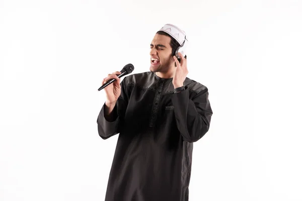 Arabisk hane i etniska klänning sjunger i karaoke. — Stockfoto