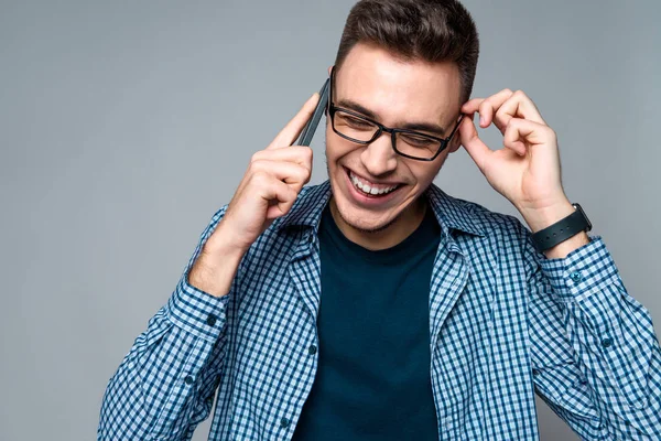 Jonge slimme jongen gesprekken op telefoon, aanpassing van de bril — Stockfoto