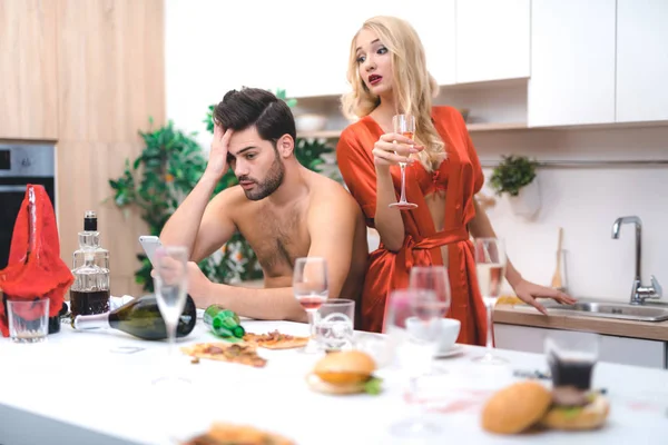 Young lovers watching photos after crazy sex party — Stock Photo, Image