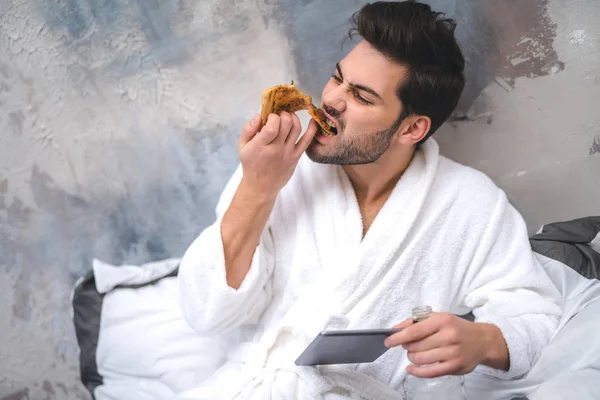 Homem vestido comendo pizza e beber em casa — Fotografia de Stock