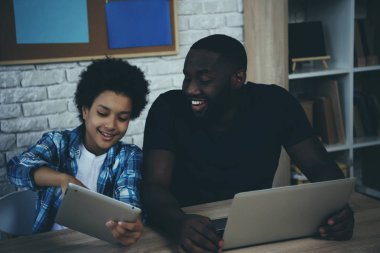 Afro-Amerikan çocuk ekran tablet için baba gösterir.
