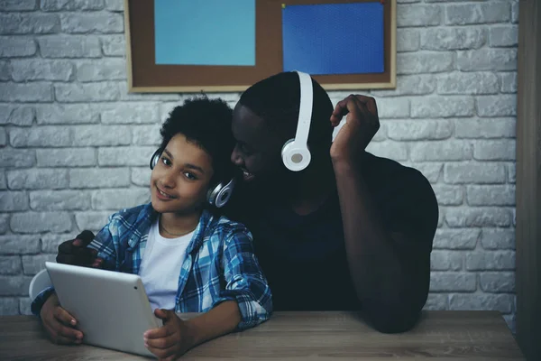 Negro adolescente chico en auriculares escuchando música — Foto de Stock
